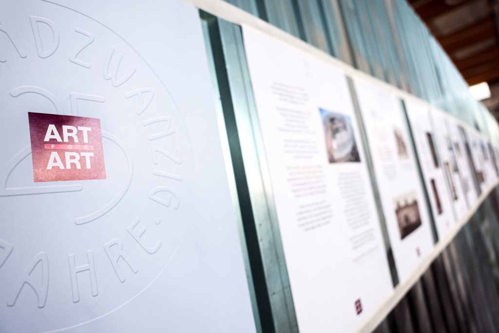 Tafeln mit Ausstellungstexten und Bildern, links ein Logo mit der Aufschrift „ART for ART“ und geprägtem Jubiläumstext.