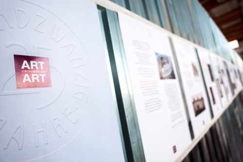 Tafeln mit Ausstellungstexten und Bildern, links ein Logo mit der Aufschrift „ART for ART“ und geprägtem Jubiläumstext.